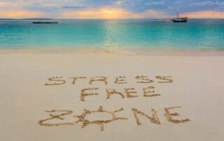 A beach with "stress free zone" written on the sand.